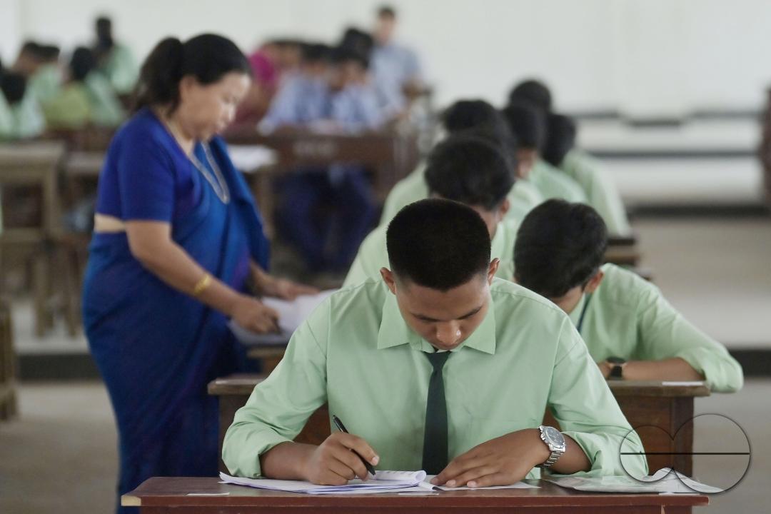 Students are seen writing an English paper