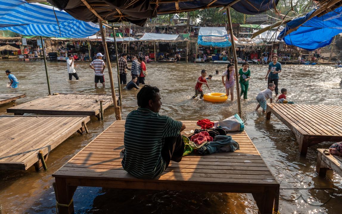 Thai and Burmese families swimming and playing in the Thailand - Myanmar Moei river border near Mae Sot, Thailand