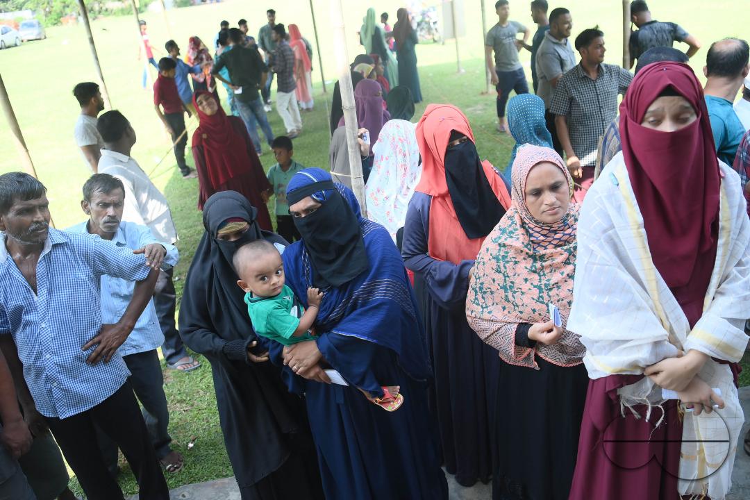 Voters wait in a queue to cast their votes during the by-elections for the Boxonagar assembly seat, in Tripura Sepahijala district