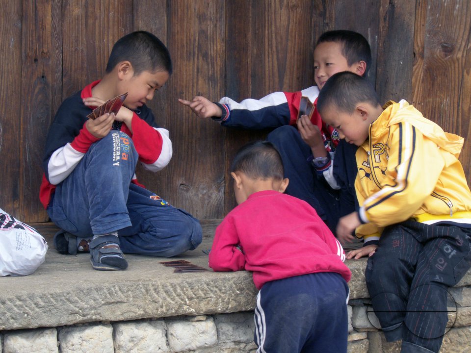 CHINA Children playing cards in a village in Yunnan province.