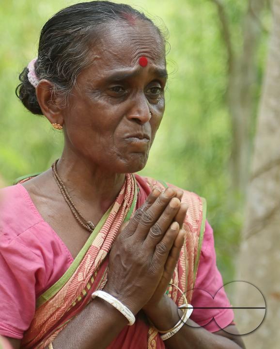 An elderly woman is crying in front of local MLAS officials at her makeshift tent at the Panisagar's reserve forest