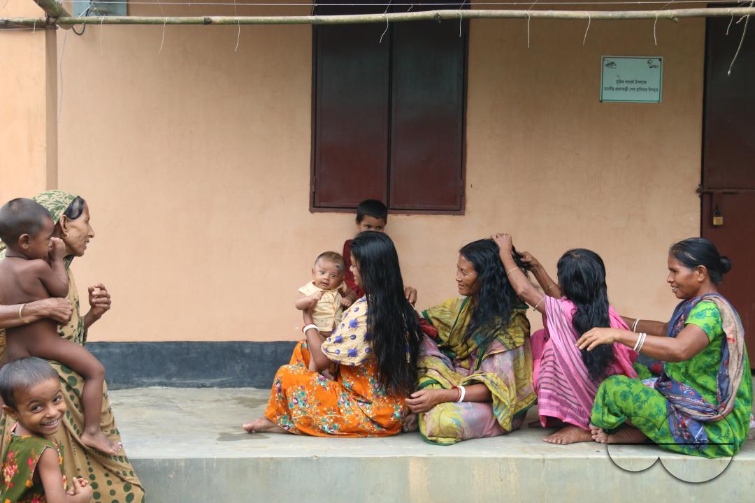 Rural Bangladeshi women use fingers to separate hair and create a part