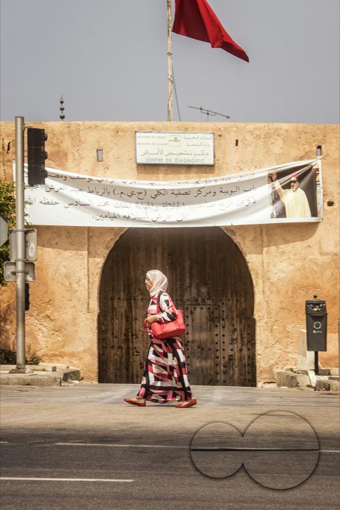 A woman walks past a gateway to the medina