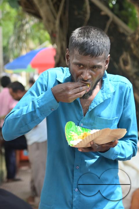 People eating food distributed by a social worker on World Food Safety Day organised by "Roti Bak Foundation", in Agartala