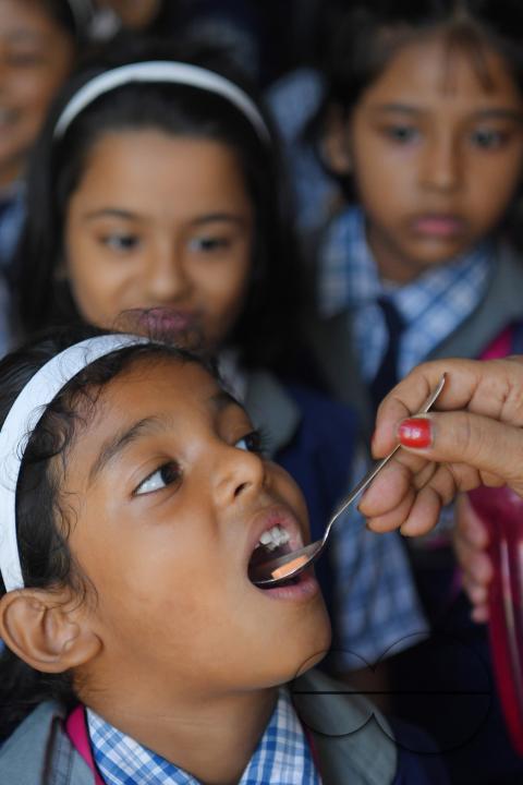 A schoolteacher is giving deworming tablets to the students in a school during the special program of Mukhyamantri Sustho Shoishob, Sustho Kaishore Abhiyan (MSSSKA 5'0) for National Deworming Day