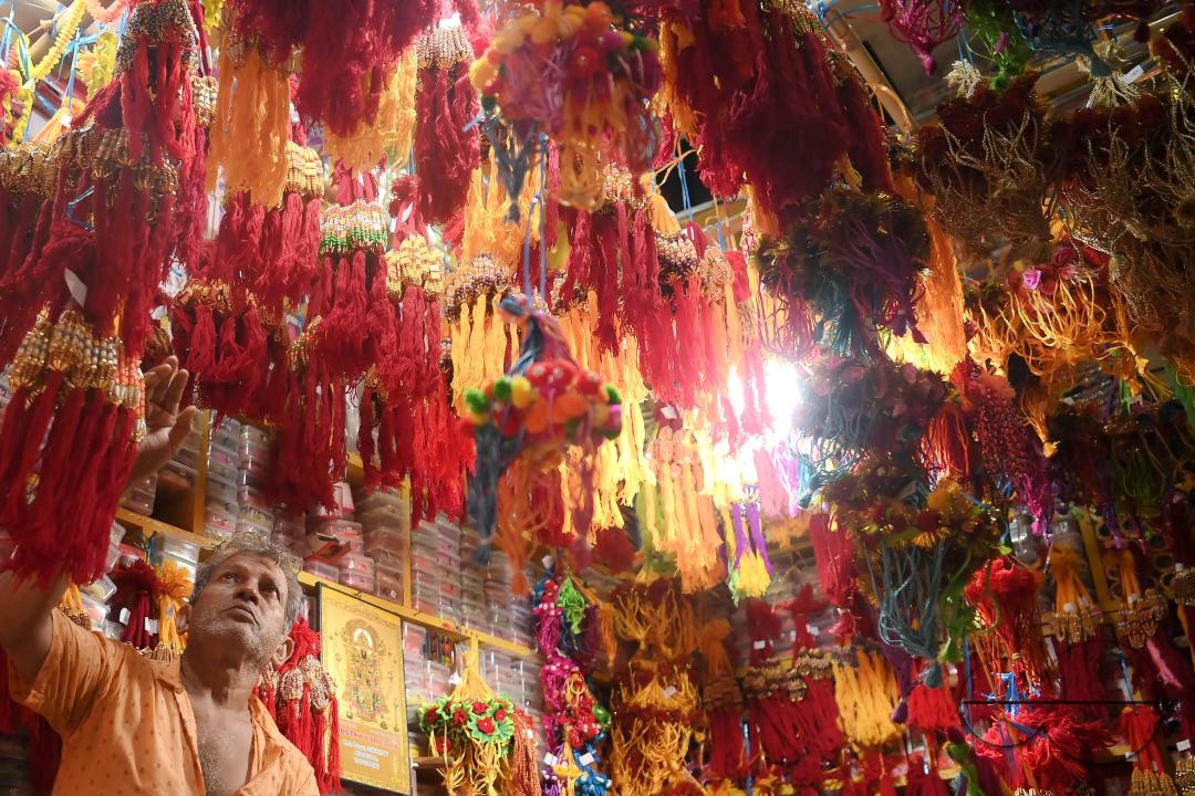 A shop owner arranging "Rakhi", sacred threads for the upcoming "Raksha Bandhan" festival at his shop in Agartala