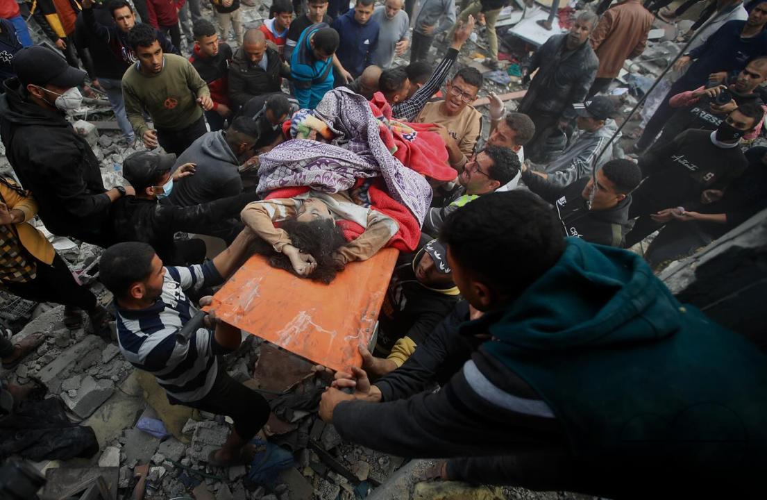 Palestinians carry the body of a child who was recovered from under the rubble of her home in Khan Yunis, south of the Gaza Strip