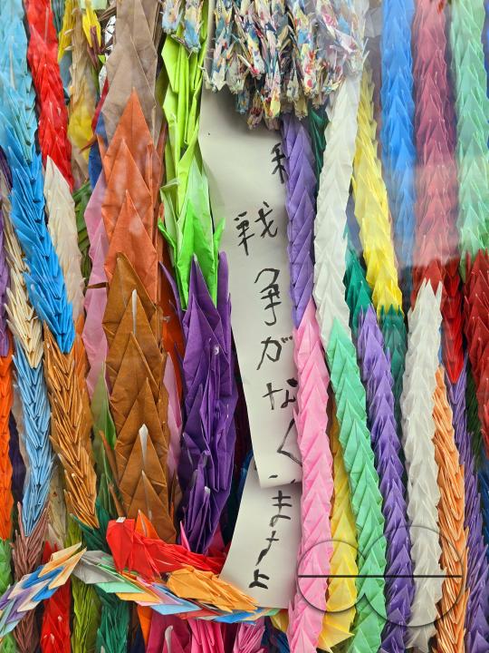 Multicoloured paper ribbons, woven by children and other visitors, are tied to the railings of the Peace Memorial Park Center, as a symbol of love and harmony