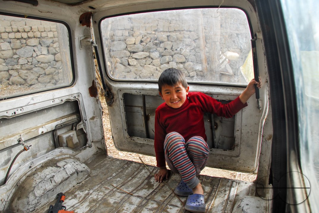 A boy playing inside an old Maruti Van parked in a backyard in Leh, Ladakh.