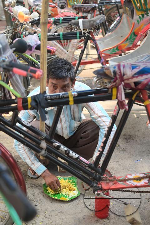 A rickshaw puller eats food distributed by a social worker on World Food Safety Day organised by Rotary Club of Agartala, in Agartala