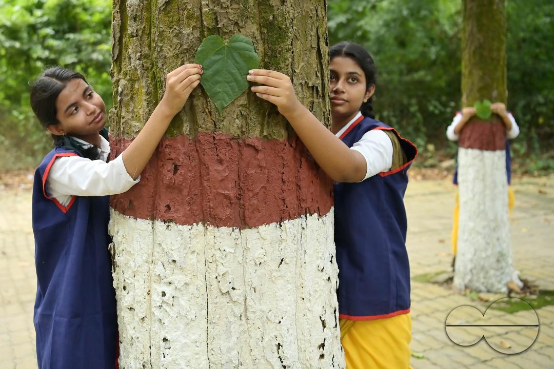 NSS (National Service Scheme) volunteers and school students of Netaji Subhas Vidyaniketan hug trees on the eve of World Nature Conservation Day