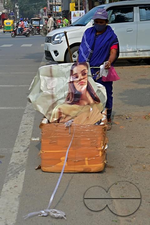An employee of the municipality sweeps and collects garbage into a collection box in Agartala