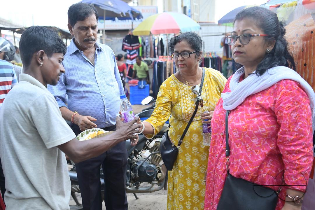 People get food from a social worker on World Food Safety Day, organised by Rotary Club of Agartala, in Agartala