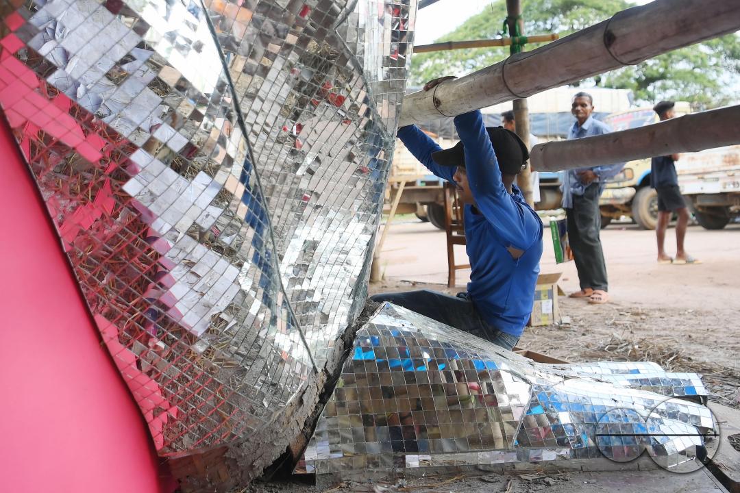 An artist is pasting glass pieces to make a 41 feet tall Ganesh idol, fully covered by glass, ahead of Ganesh Chaturthi festival in a pandal in Ranir bazar