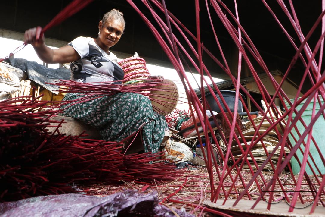 A woman weaves a household basket at Nigeria's largest cane 'village' at Mende in the Maryland District of Lagos