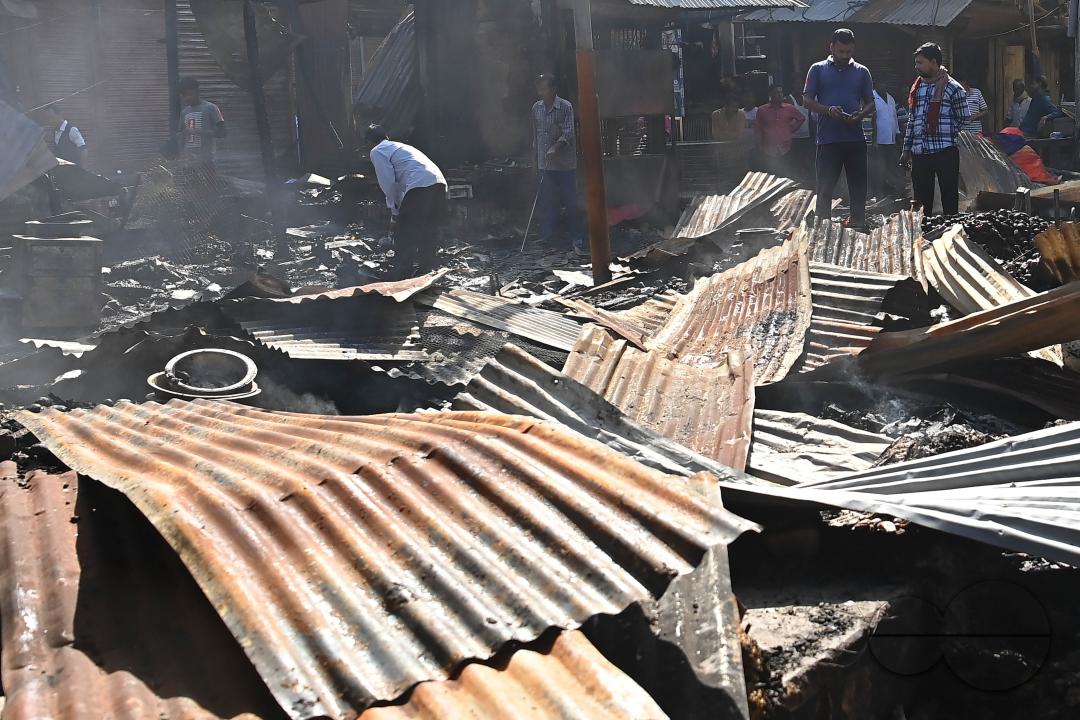 Shop owners and vendors are seen in front of their burnt shops and vegetables stalls in Battala market, the second biggest market in Tripura