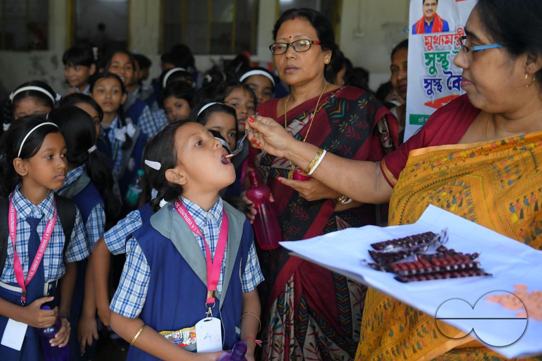 A schoolteacher is giving deworming tablets to the students in a school during the special program of Mukhyamantri Sustho Shoishob, Sustho Kaishore Abhiyan (MSSSKA 5'0) for National Deworming Day