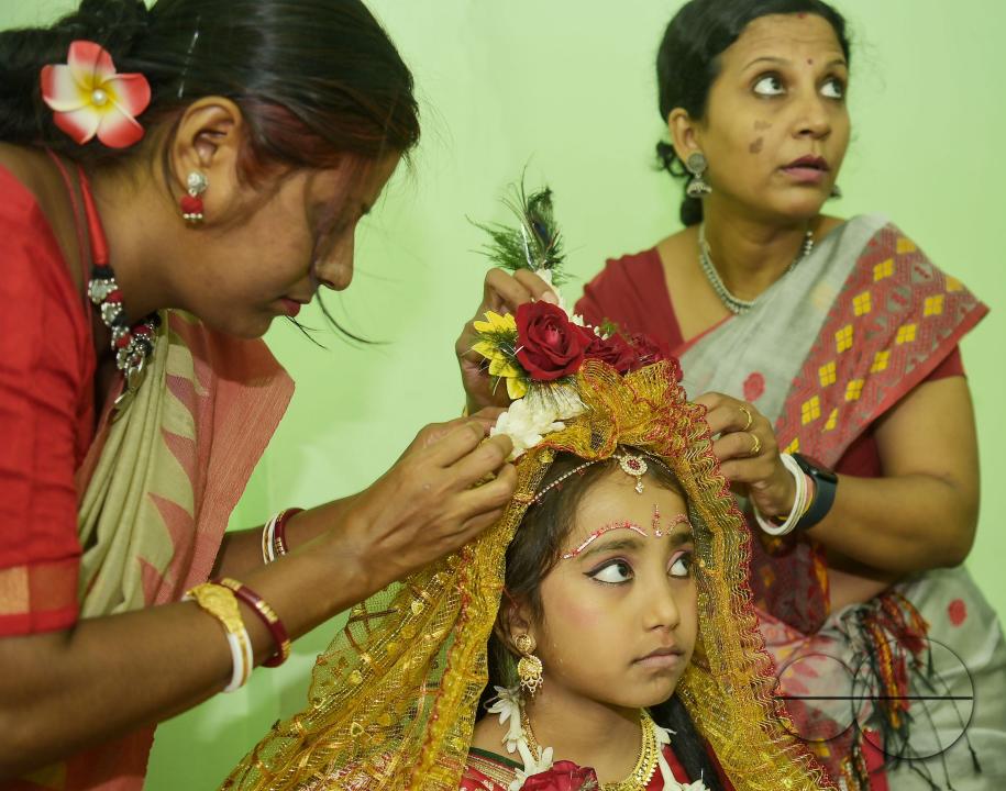 Devotees prepare the nine-year, five-month, and fourteen-day-old Hindu girl Debalina Chakraborty, known as a "Kumari," as she yawns while awaiting worship by priests during Durga Puja at the Ramakrishna Vivekananda Ashram