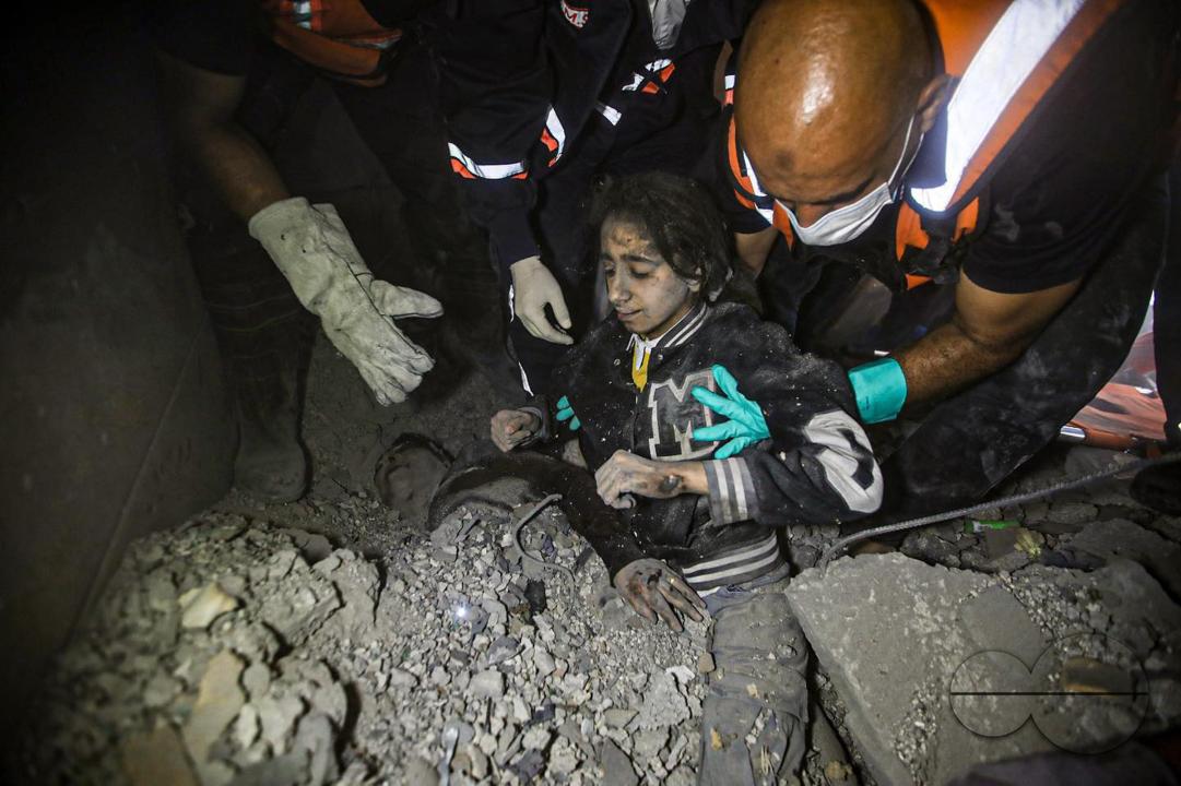 A Palestinian girl and her mother emerge from under the rubble in Khan Yunis, south of Gaza City