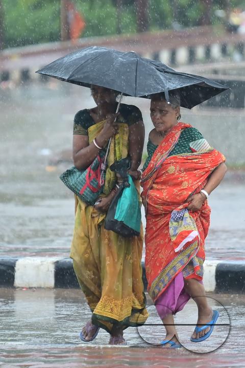 Train passengers are coming to Agartala railway station to catch the rescheduled interstate trains in heavy rain during Cyclone Remal in Agartala