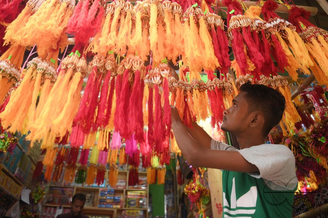 A shop owner arranging "Rakhi", sacred threads for the upcoming "Raksha Bandhan" festival at his shop in Agartala