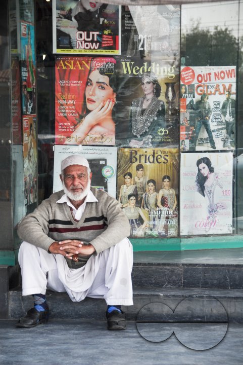 A man sitting outside a magazine store, Lahore