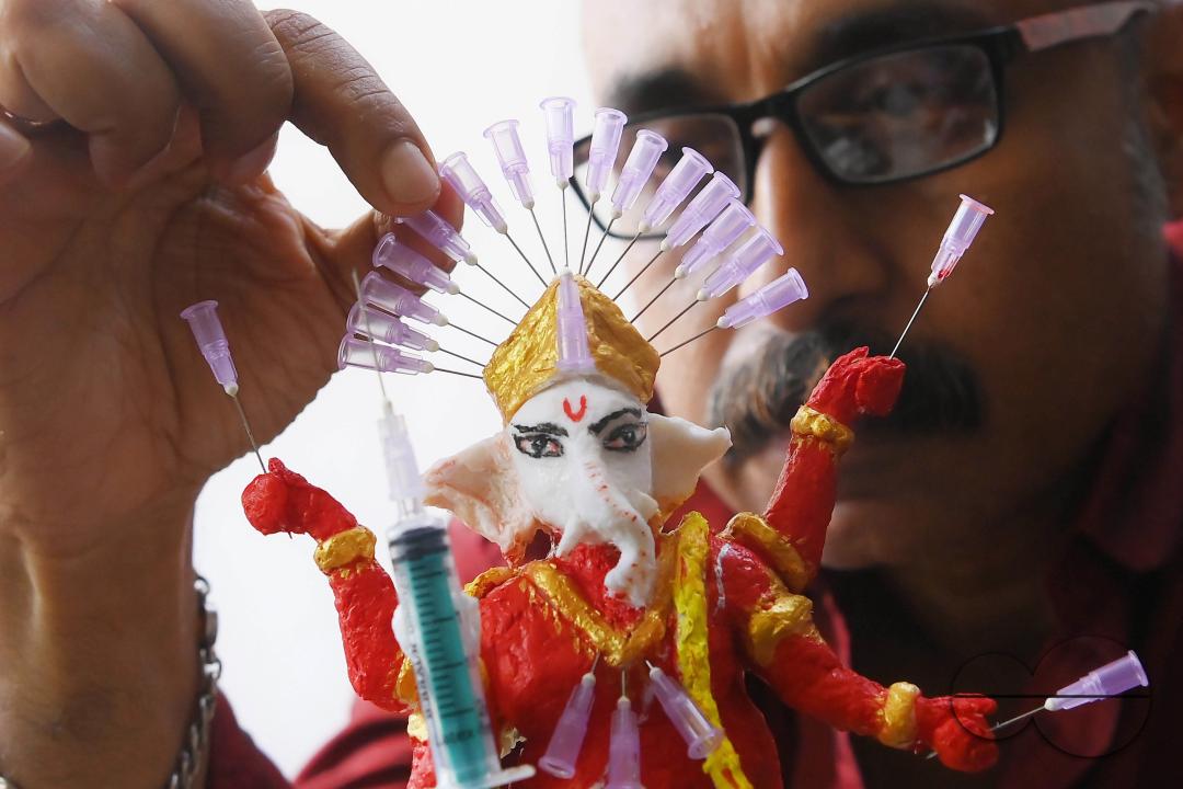 Samiran De, an artist works on an idol of Lord Ganesha made with soup and syringe needles to alert people against drugs, ahead of Ganesh Chaturthi festival, in Agartala