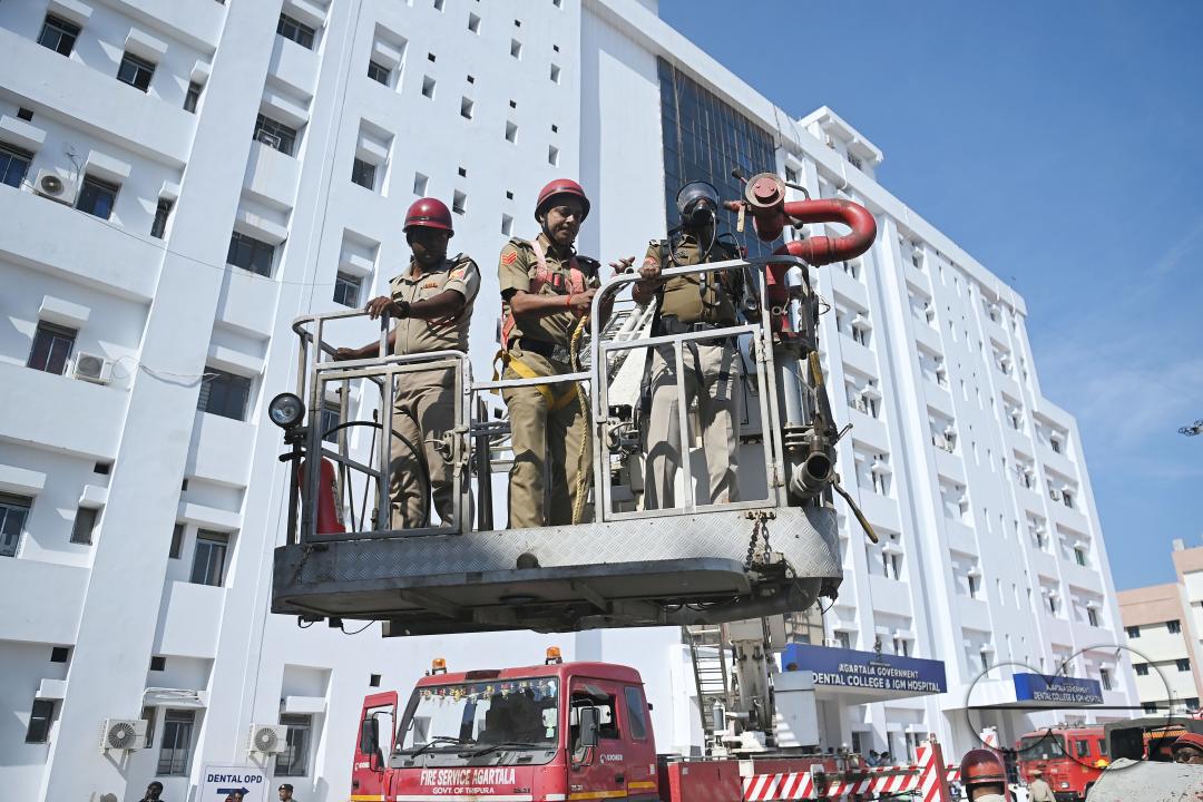 Fire brigade personnel are trying to control a fire on the top of the building of the dental college during a state level mock exercise on earthquake day at Agartala