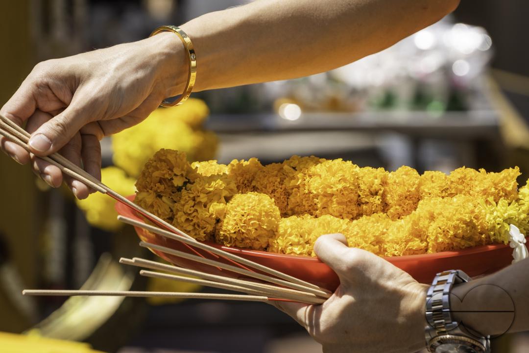 A close-up showcases a garland of flowers and incense sticks as an offering, at the Erawan Shrine in downtown Bangkok