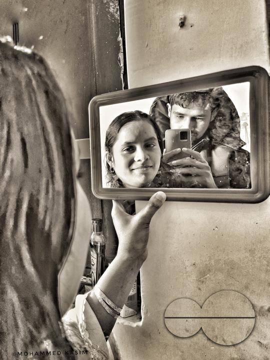 A couple looking at a small mirror at the Balukhali refugee camp