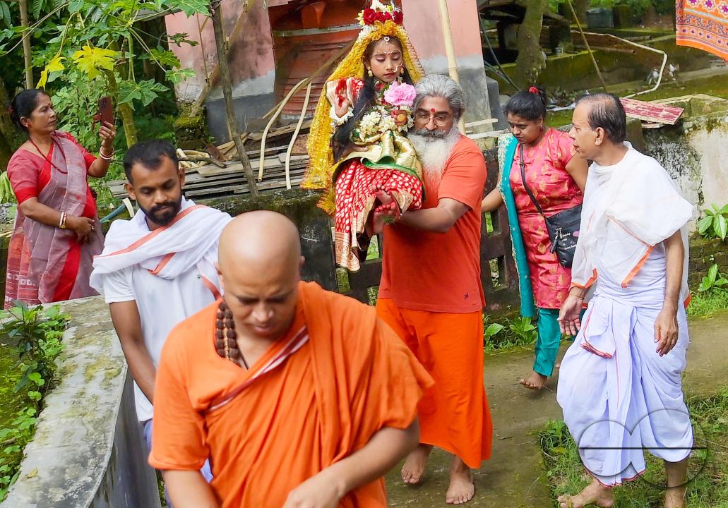 Priests carry the nine-year, five-month, and fourteen-day-old Hindu girl Debalina Chakraborty, known as a "Kumari," to the Puja site