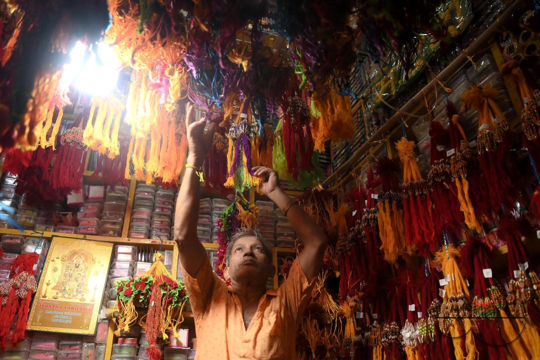 A shop owner arranging "Rakhi", sacred threads for the upcoming "Raksha Bandhan" festival at his shop in Agartala