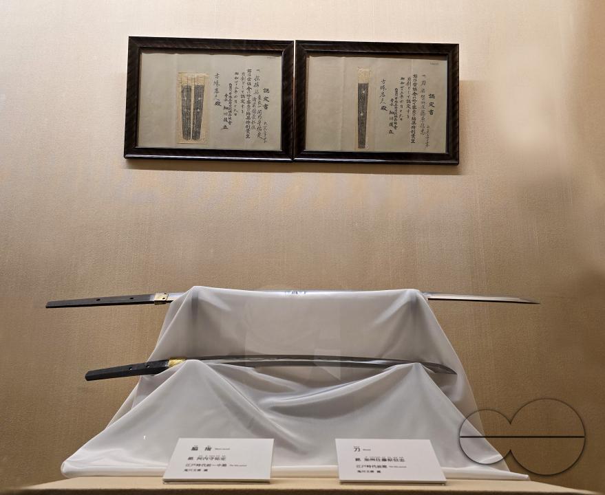 A katana is a Japanese sword characterized by a curved, single-edged blade with a circular or squared guard and long grip to accommodate two hands