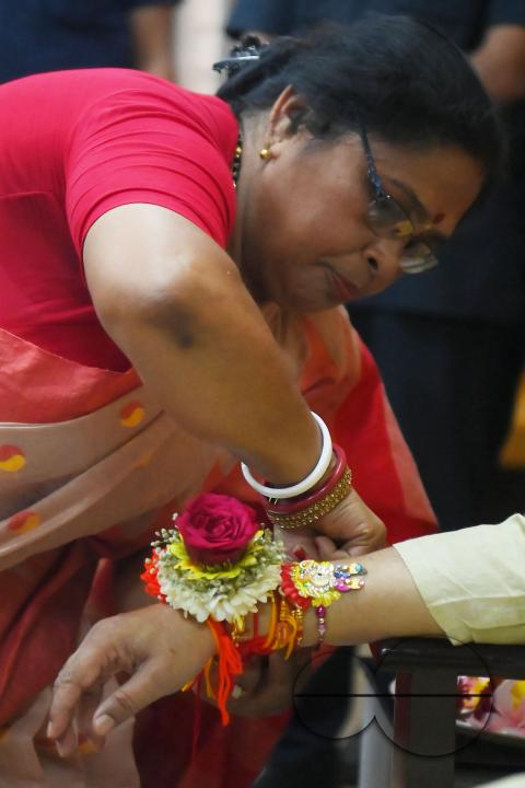 A lady tying rakhi and doing other rituals to Tripura CM Professor Dr