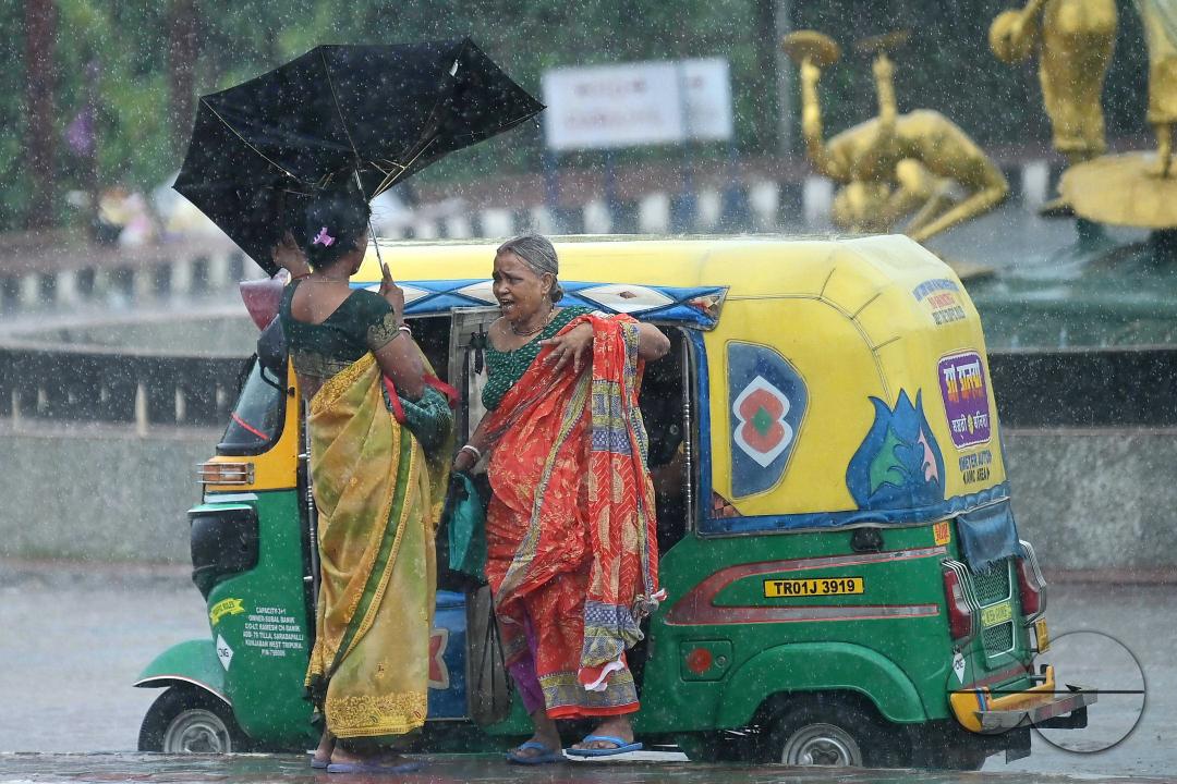 Train passengers are coming to Agartala railway station to catch the rescheduled interstate trains in heavy rain during Cyclone Remal in Agartala