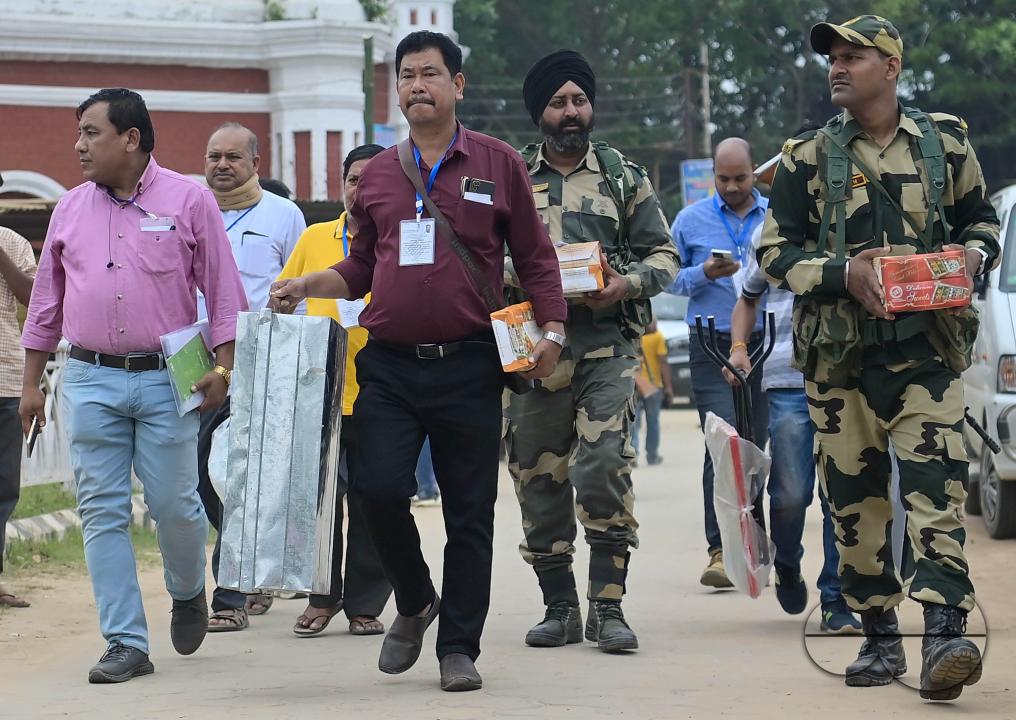 Election officials are coming out from the center with security personnel as they prepare to go door to door to collect votes