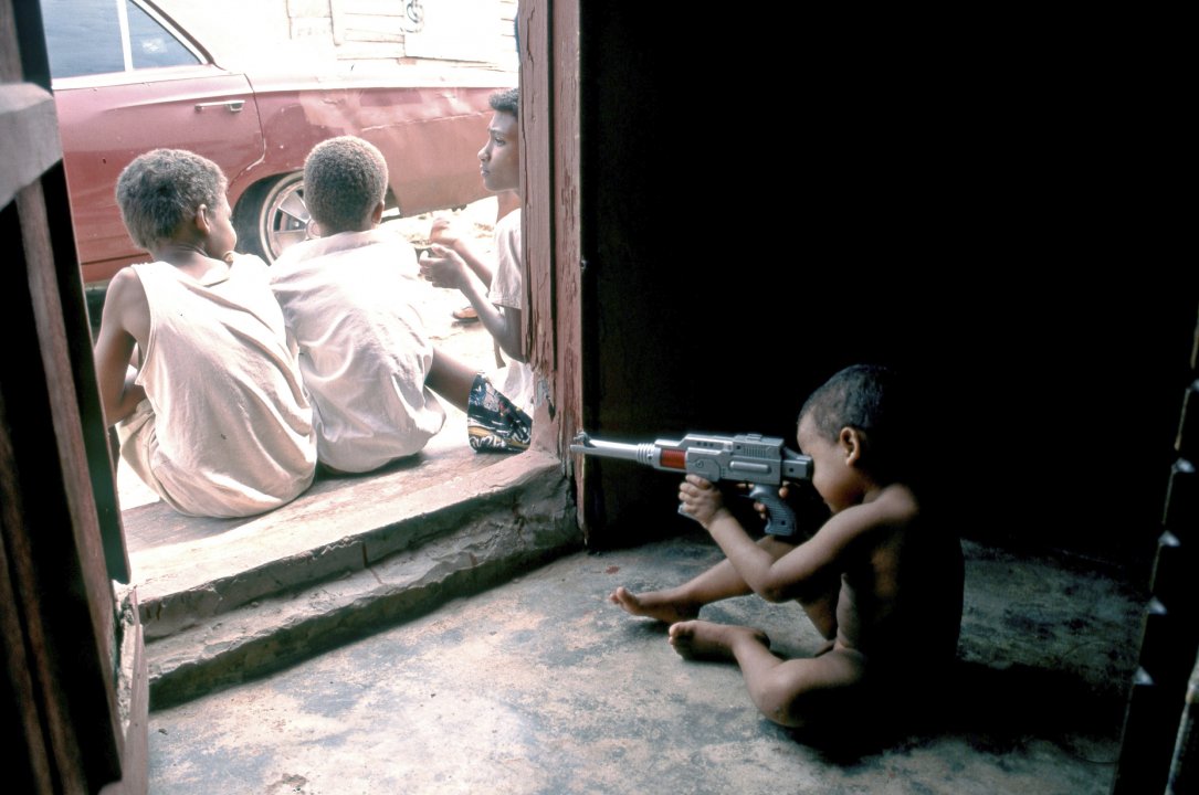 DOMINICAN REPUBLIC CHILD PLAYING WITH TOY MACHINE GUN IN THE OUTSKIRTS OF SANTO DOMINGO. Photo  Julio Etchart