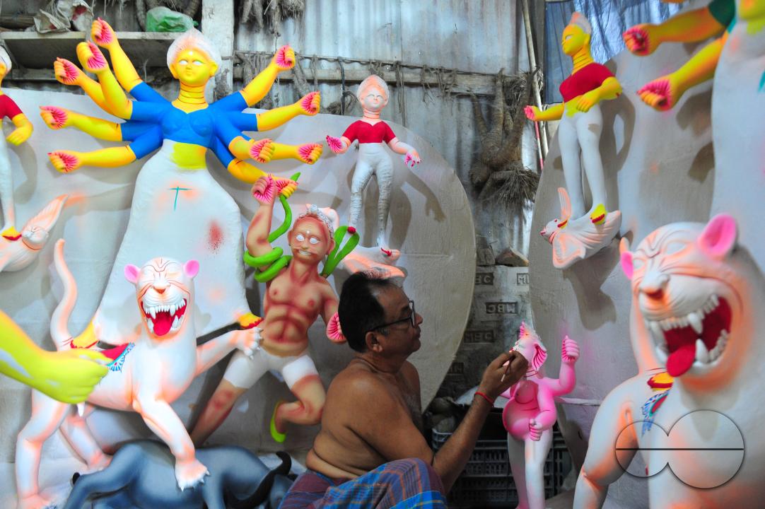 Dulal Paul, a veteran Idol Artist is colouring structures of a Hindu Deity in preparation for the upcoming Durga Puja Festival