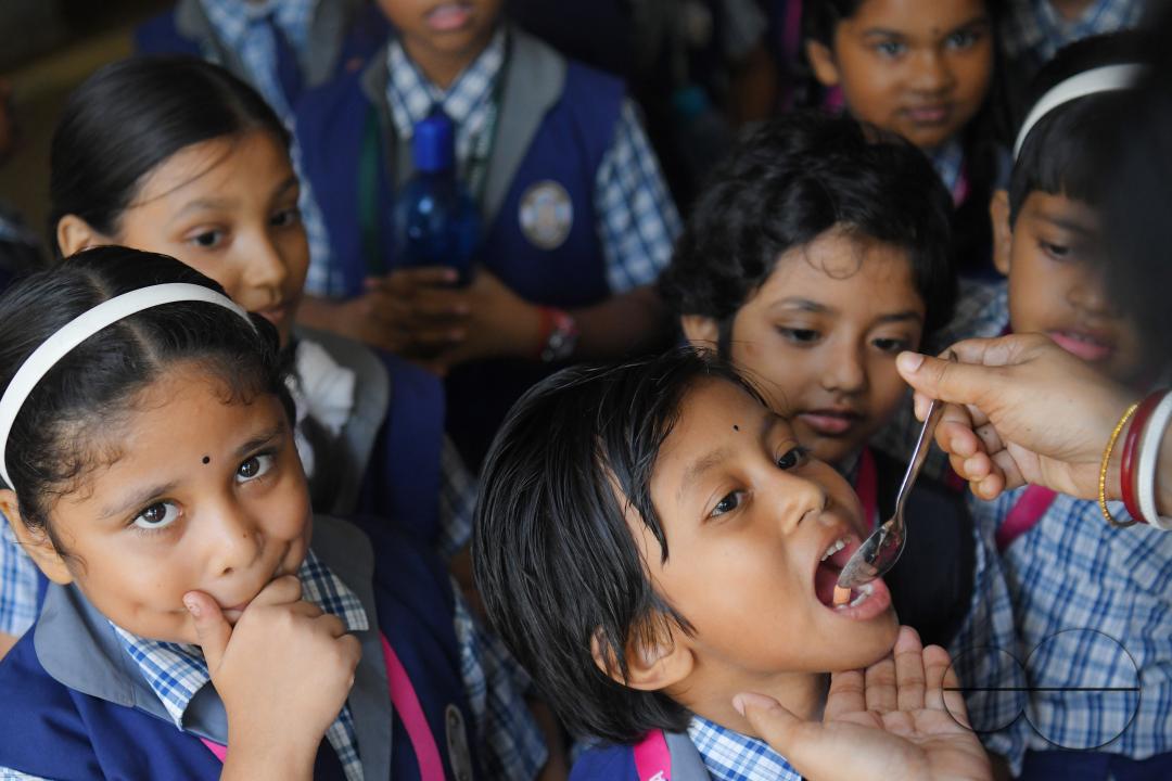 A schoolteacher is giving deworming tablets to the students in a school during the special program of Mukhyamantri Sustho Shoishob, Sustho Kaishore Abhiyan (MSSSKA 5'0) for National Deworming Day
