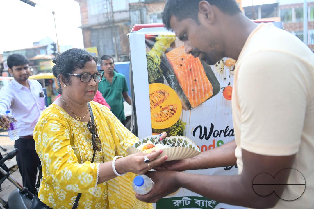 People get food from a social worker on World Food Safety Day, organised by "Roti Bank Foundation", in Agartala