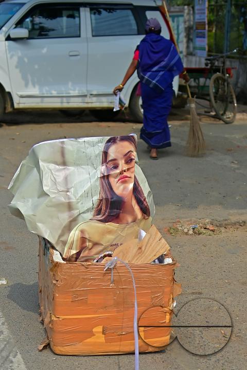 An employee of the municipality sweeps and collects garbage into a collection box in Agartala