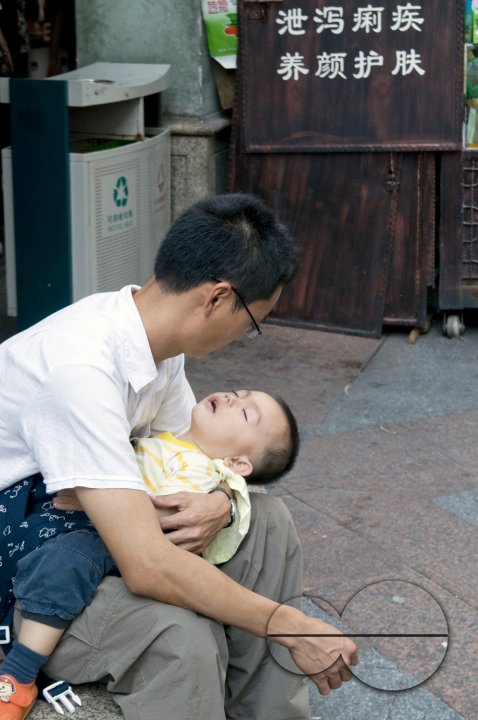 CHINA father with sleeping son in Guangzhou, Guangdong province..