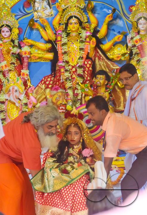 Priests worship a nine-year, five-month, and fourteen-day-old Hindu girl, Debalina Chakraborty, known as a "Kumari," who yawns during the Durga Puja religious festival at the Ramakrishna Vivekananda Ashram, operated by the Ramakrishna Mission on the outs