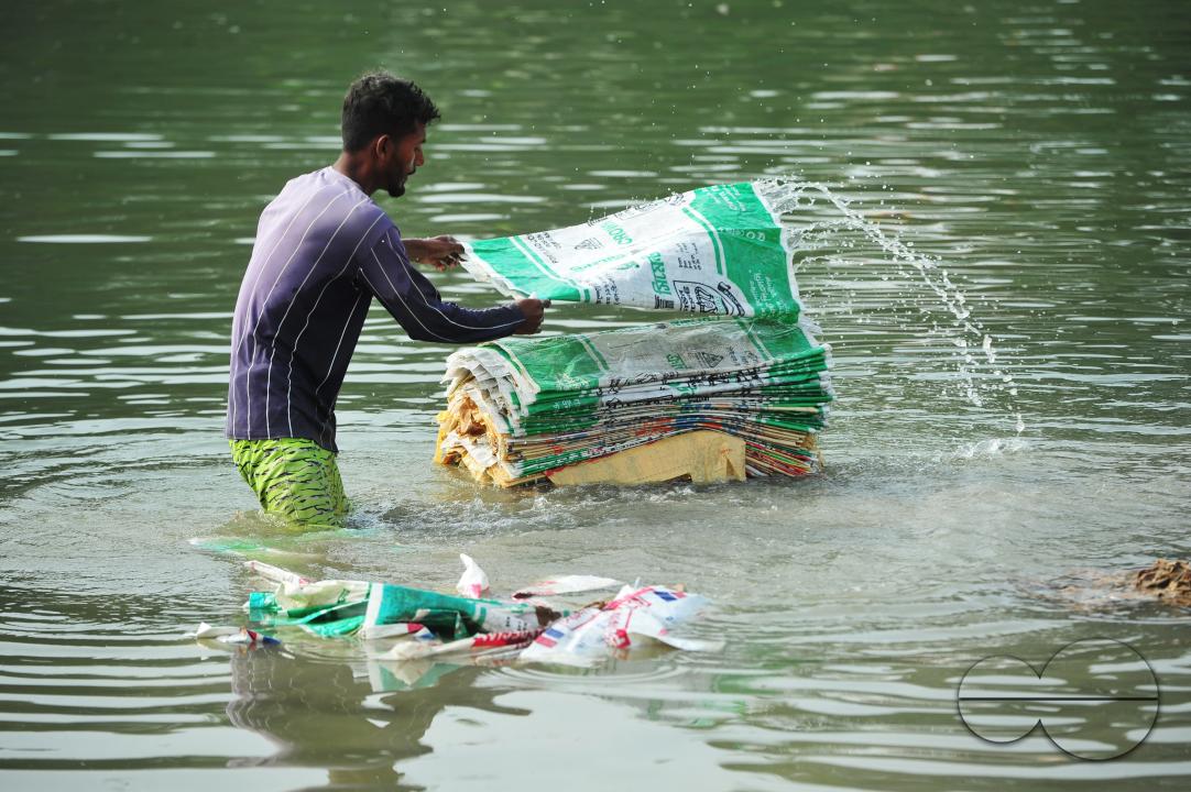 Women are risking their lives to wash cement bags beside the Surma River in Sylhet