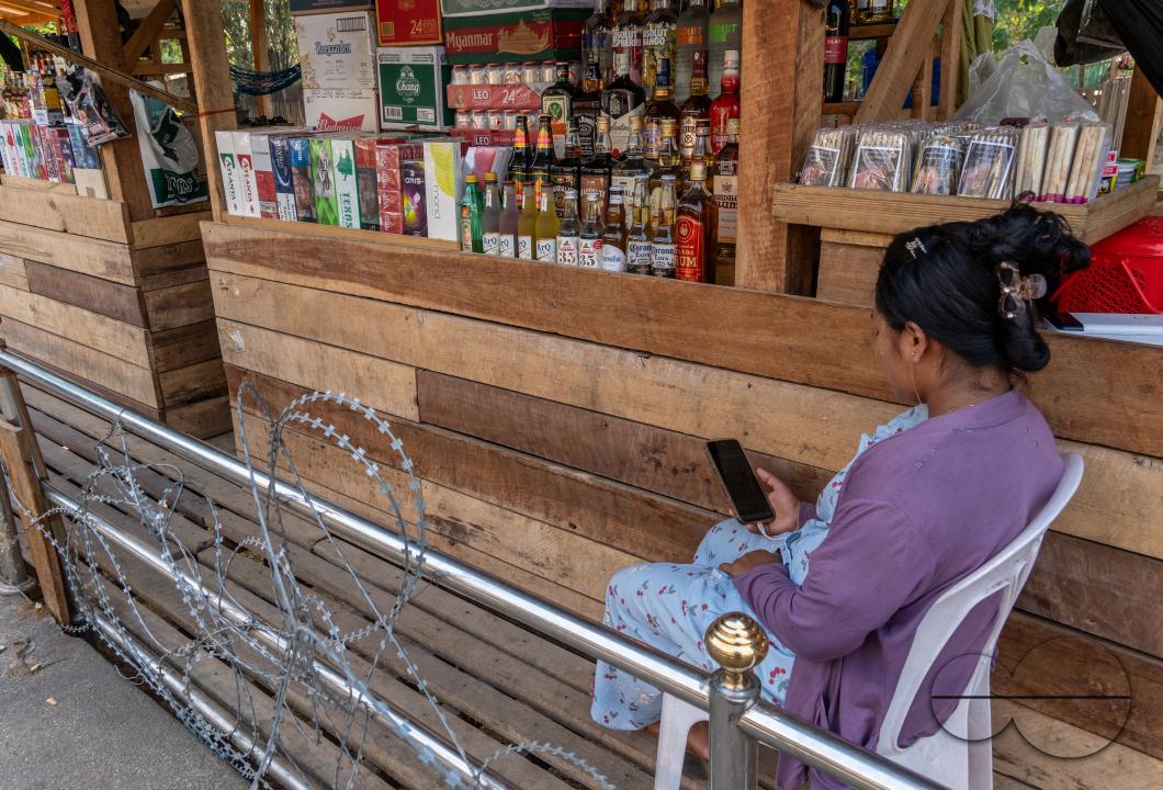 Visitors, traders and illegal Burmese immigrants walk by barbed wire at the Thai side of the Thailand - Myanmar border at Mae Sot, Thailand.