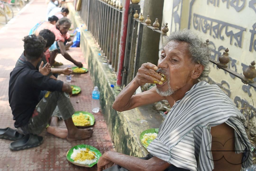 People eating food distributed by a social worker on World Food Safety Day organised by "Roti Bak Foundation", in Agartala