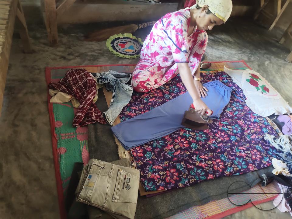 A woman ironing with an old fashioned charcoal iron at the Balukhali refugee camp