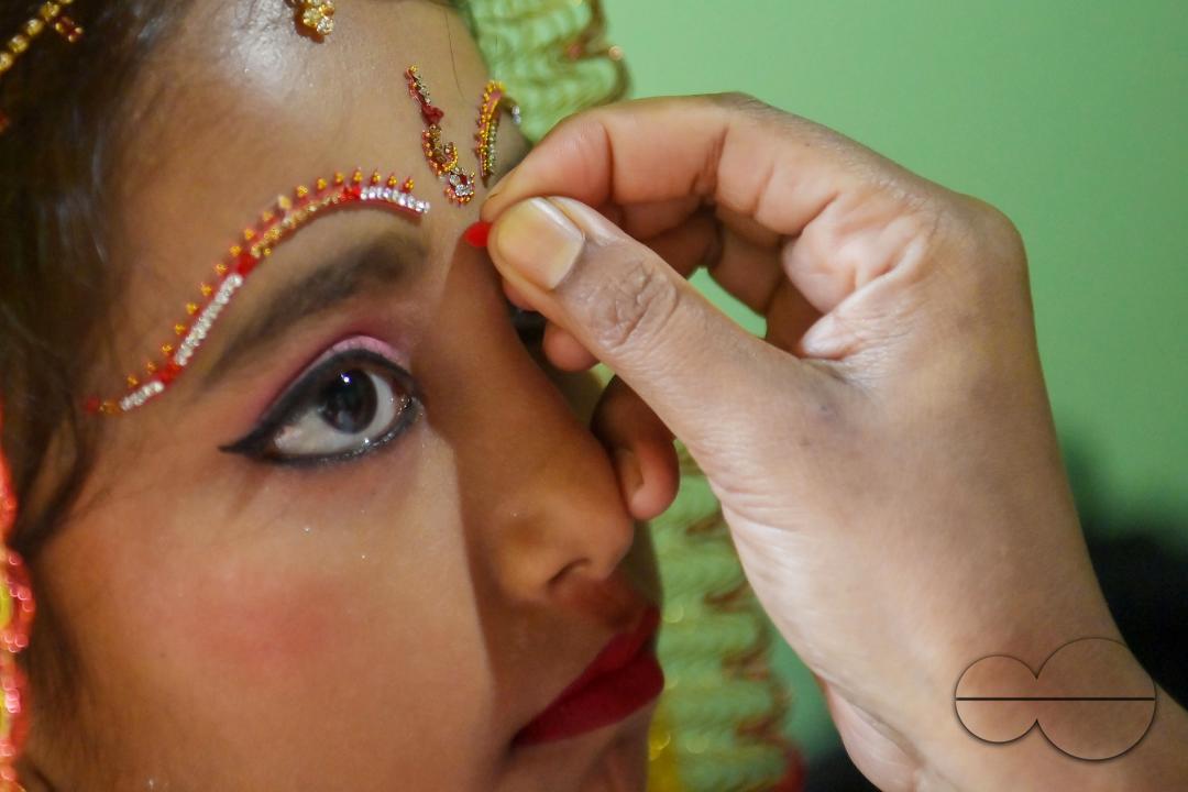 Devotees prepare the nine-year, five-month, and fourteen-day-old Hindu girl Debalina Chakraborty, known as a "Kumari," as she yawns while awaiting worship by priests during Durga Puja at the Ramakrishna Vivekananda Ashram