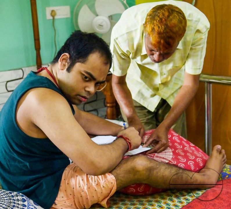 A differently abled boy going through the pre vote procedures before casting his postal ballot vote with the assistance of her family members at her house in front of the team of election officials and security personnel in Agartala