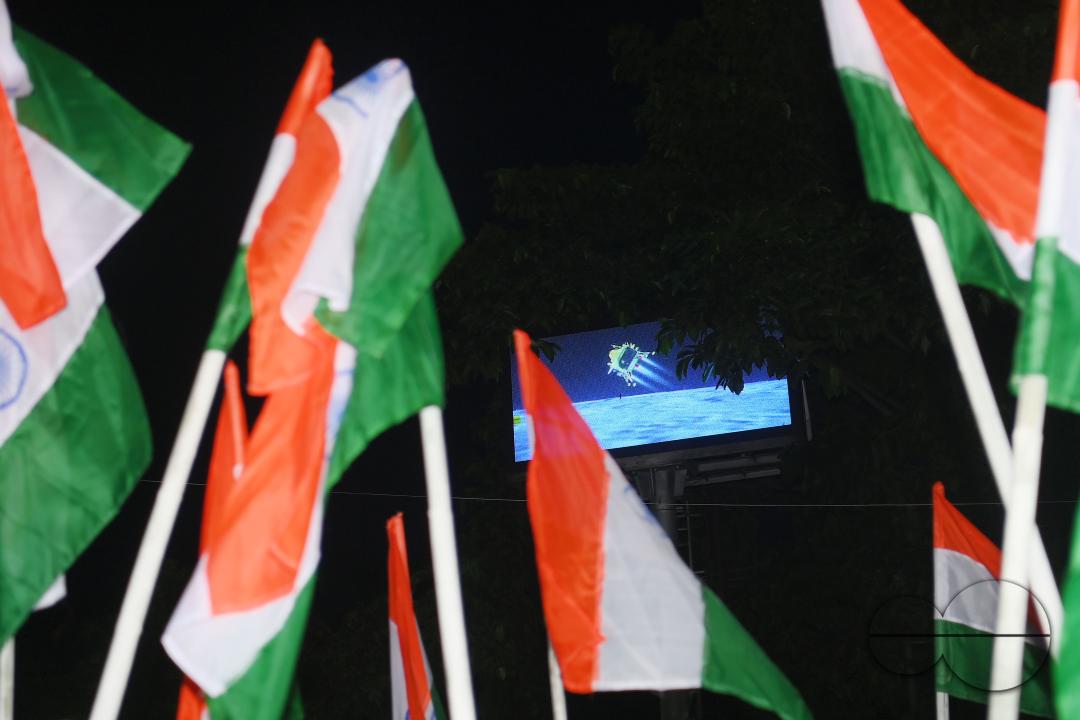 BJP party leaders, workers and the general public celebrate with the Indian flag in front of a LCD TV during the live stream of the successful lunar landing of the Chandrayaan-3 spacecraft on the south pole of the Moon, in Agartala